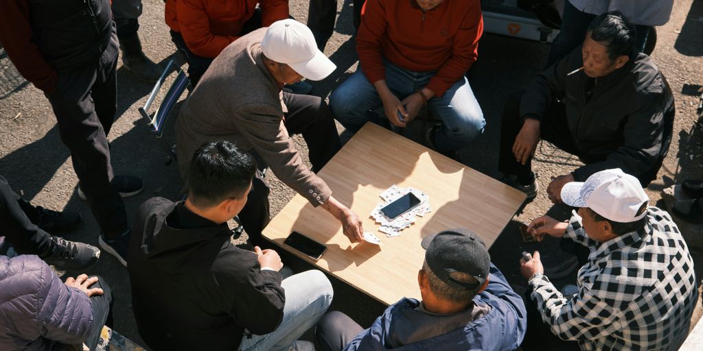 People play a game around a table.